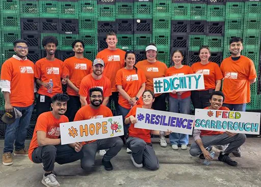 Home Depot Canada early talent team members wearing orange aprons and standing together in front of a Home Depot backdrop.