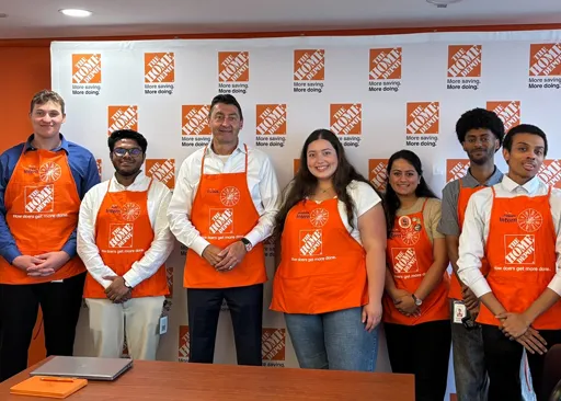 Home Depot Canada associates volunteering together, wearing orange shirts and holding signs promoting hope, dignity, and resilience.